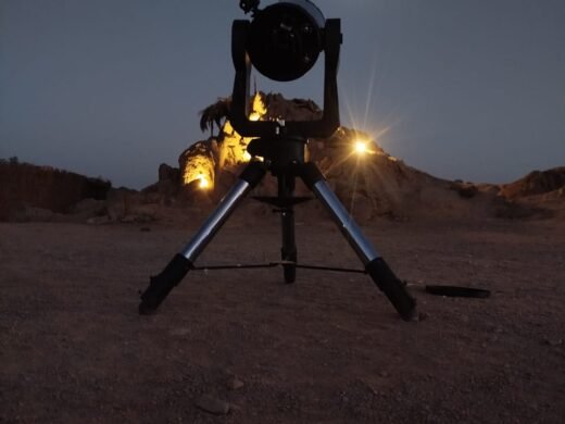Profesjonalny teleskop na statywie ustawiony do obserwacji gwiazd na egipskiej pustyni pod księżycowym niebem, wycieczka Stargazing Safari