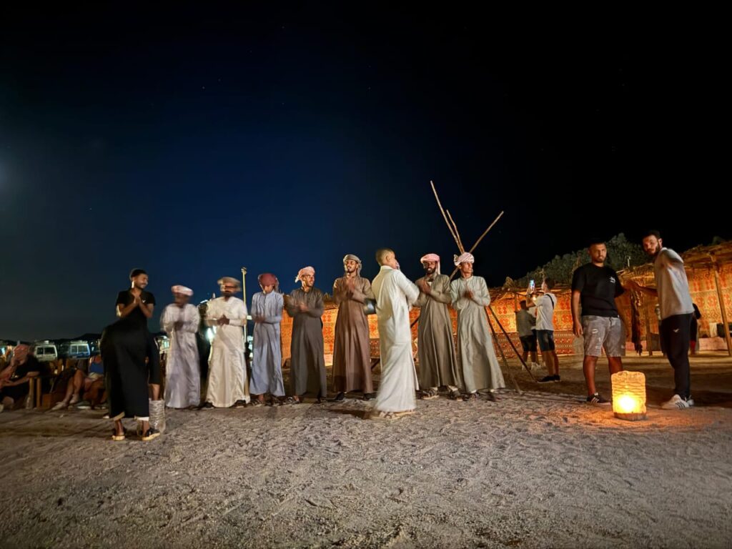 Tourists in traditional Bedouin clothing and headscarves posing during a desert stargazing safari trip in Hurghada.