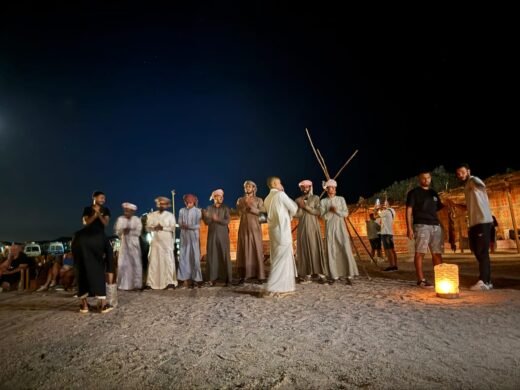 Tourists in traditional Bedouin clothing and headscarves posing during a desert stargazing safari trip in Hurghada.