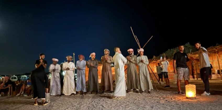 Tourists in traditional Bedouin clothing and headscarves posing during a desert stargazing safari trip in Hurghada.