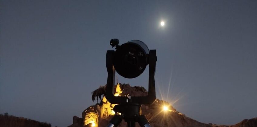 Professional telescope on a tripod set up for stargazing in the Egyptian desert under a moonlit sky, Stargazing Safari tour